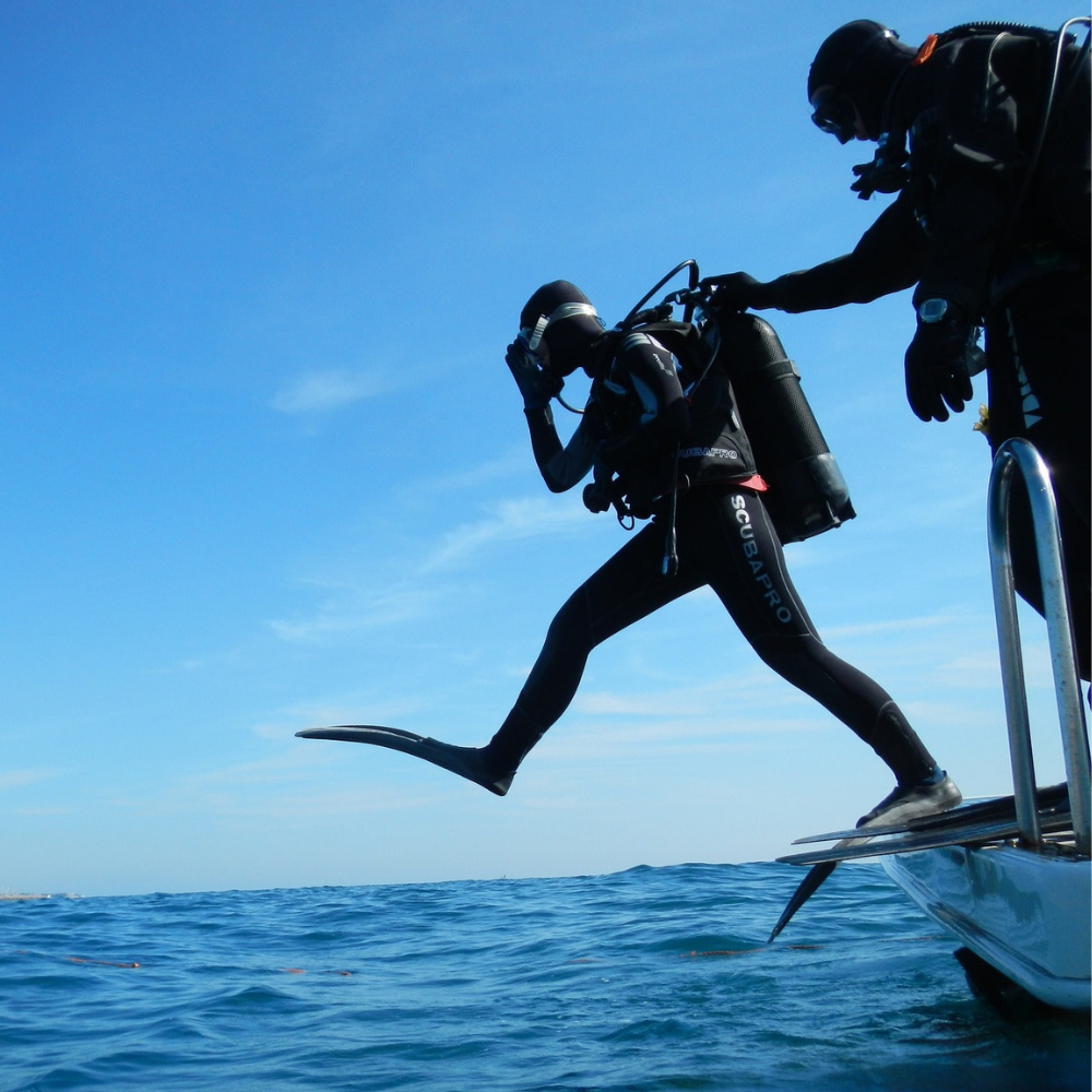 Diver and student jumping from the boat